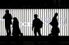 People are silhouetted as they walk past an illuminated neon sign near the Cheonggyecheon stream at night in Seoul.
