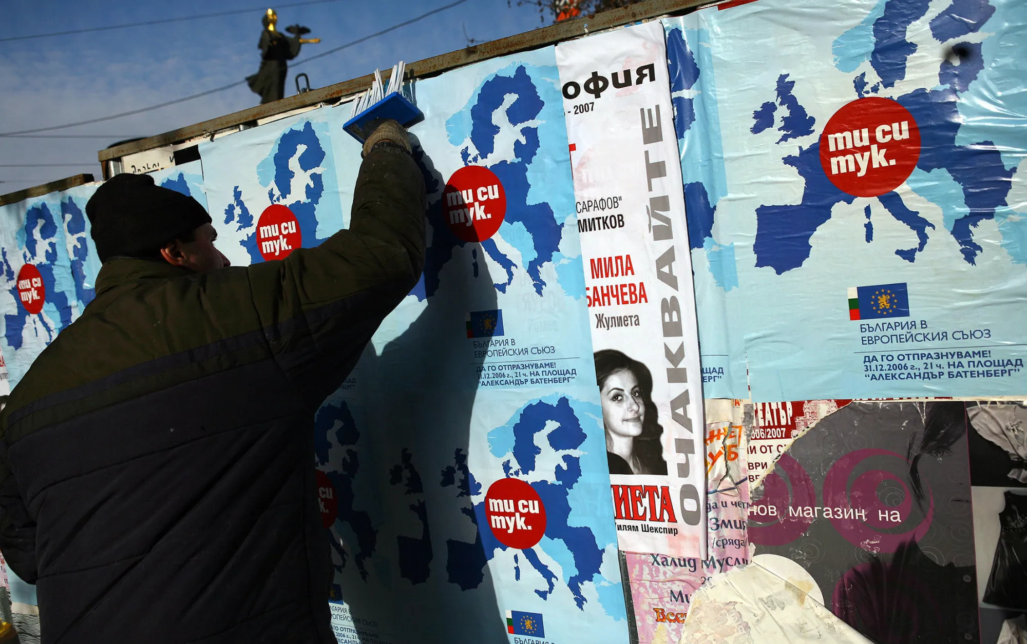 A man sticks posters of a map of the European Union with a slogan in Bulgarian reading 'You are here' and 'Bulgaria in the European Union' in Sofia, on Dec. 29, 2006.
