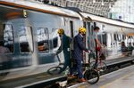 Commuters carry bicycles as they disembark from a train operated by FirstGroup Plc at London Paddington railway station.