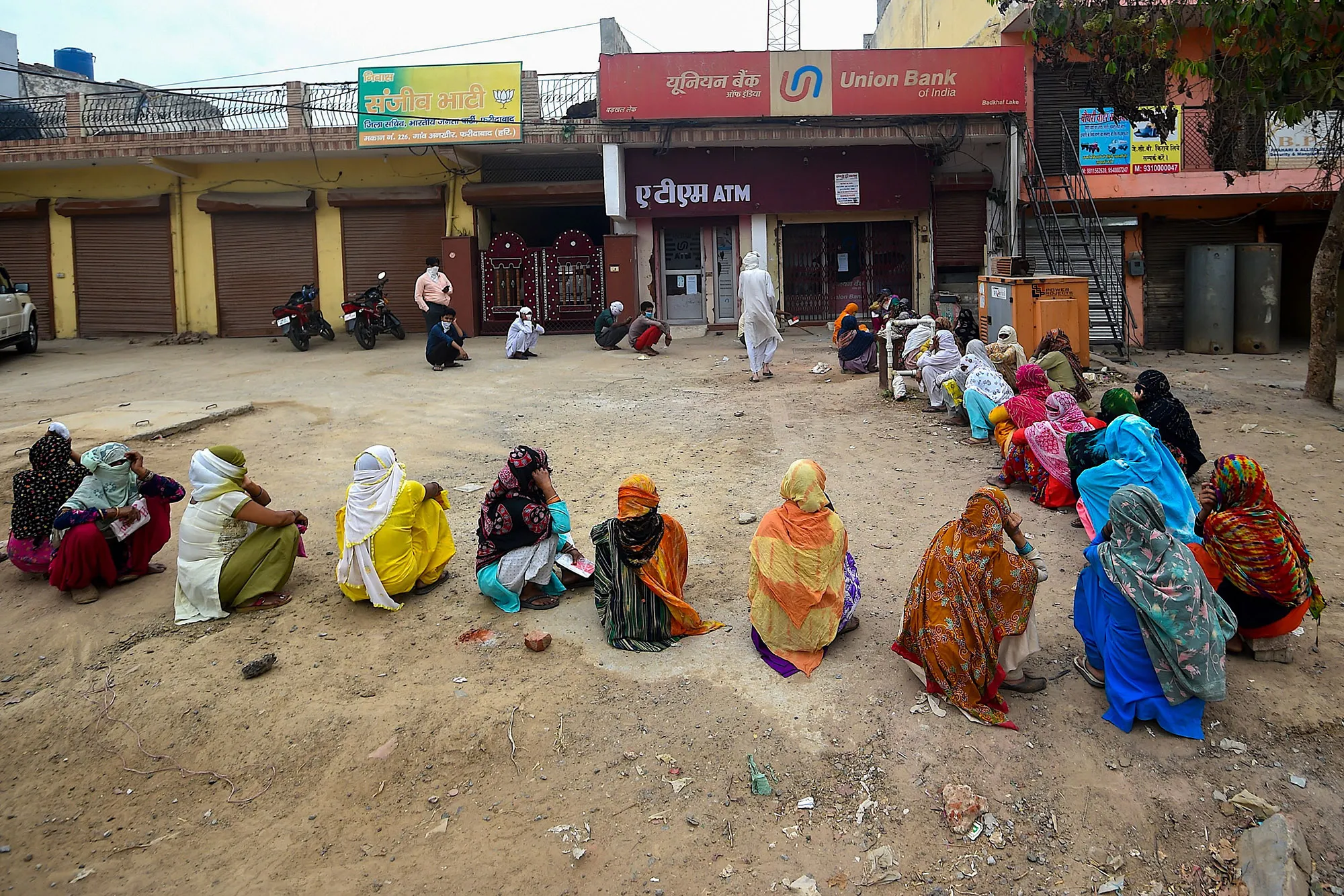 People queue outside a bank as they wait for their turn during nationwide lockdown in Faridabad on April 20.
