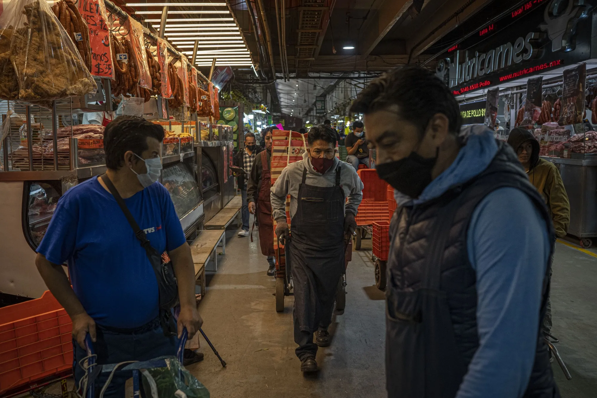 A worker pulls a cart loaded with boxes at the Central de Abastos Market in Mexico City, Mexico, on Wednesday, Jan. 12, 2022.