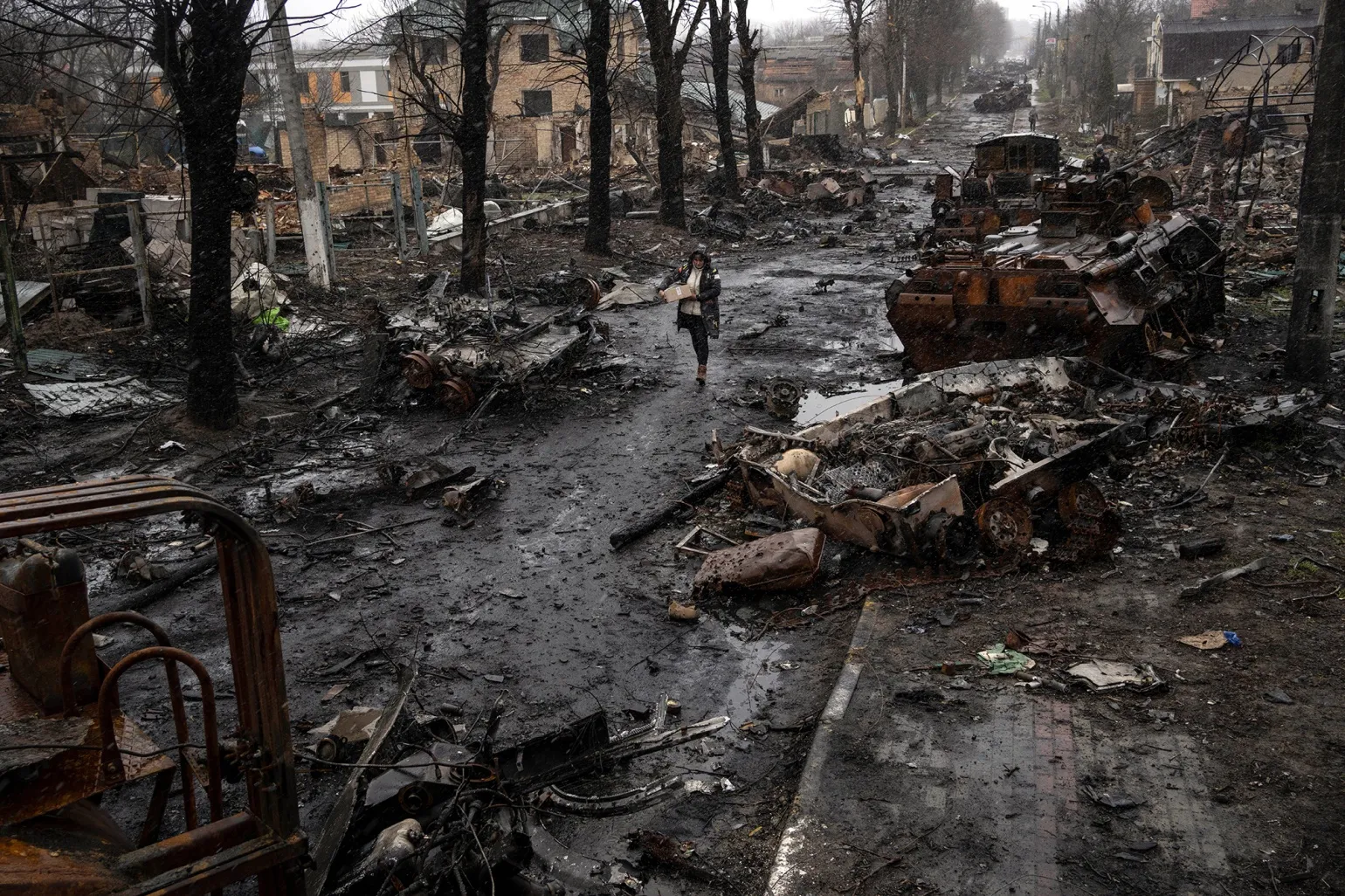 A woman walks amid destroyed Russian tanks in Bucha, on&nbsp;the outskirts of Kyiv, on April 3.
