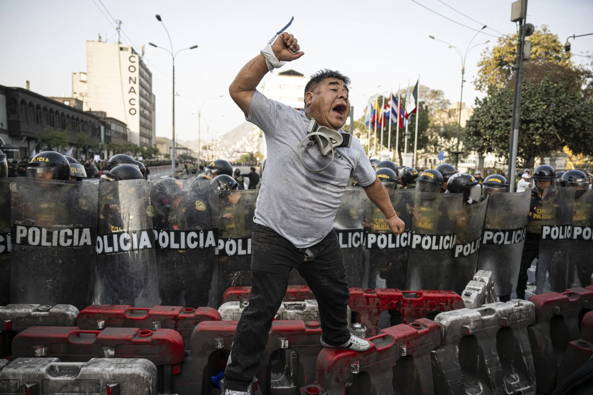A demonstrator shouts slogans in front of riot police during a protest&nbsp;in Lima on Oct.&nbsp;10.