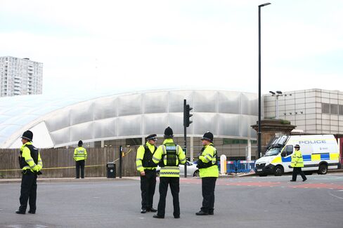 Police officers stand near the Manchester Arena, May 23.