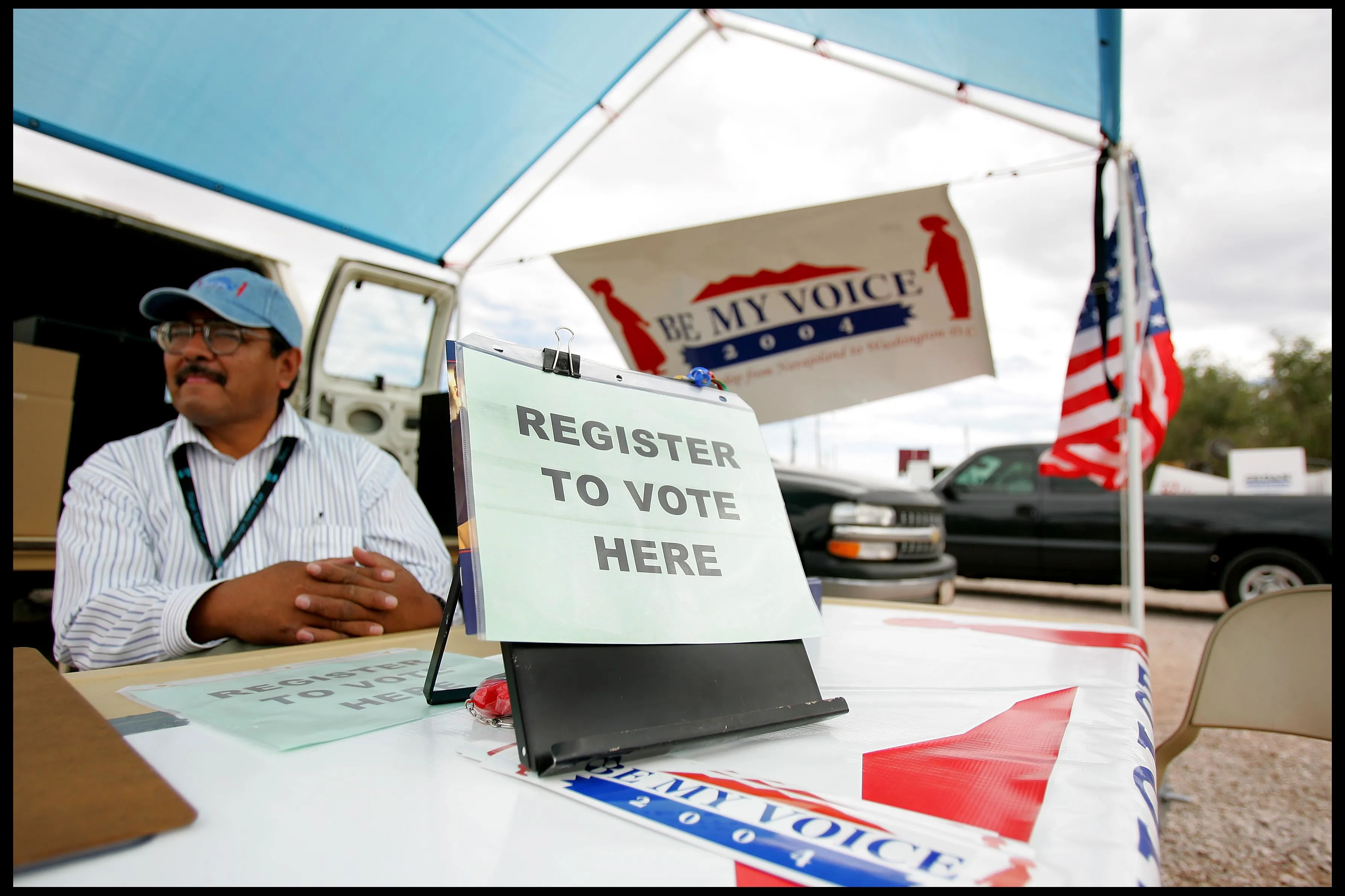 A man&nbsp;sits at the "be my voice" voter registration stand at the Navajo Nation annual rodeo, in Window Rock.&nbsp;