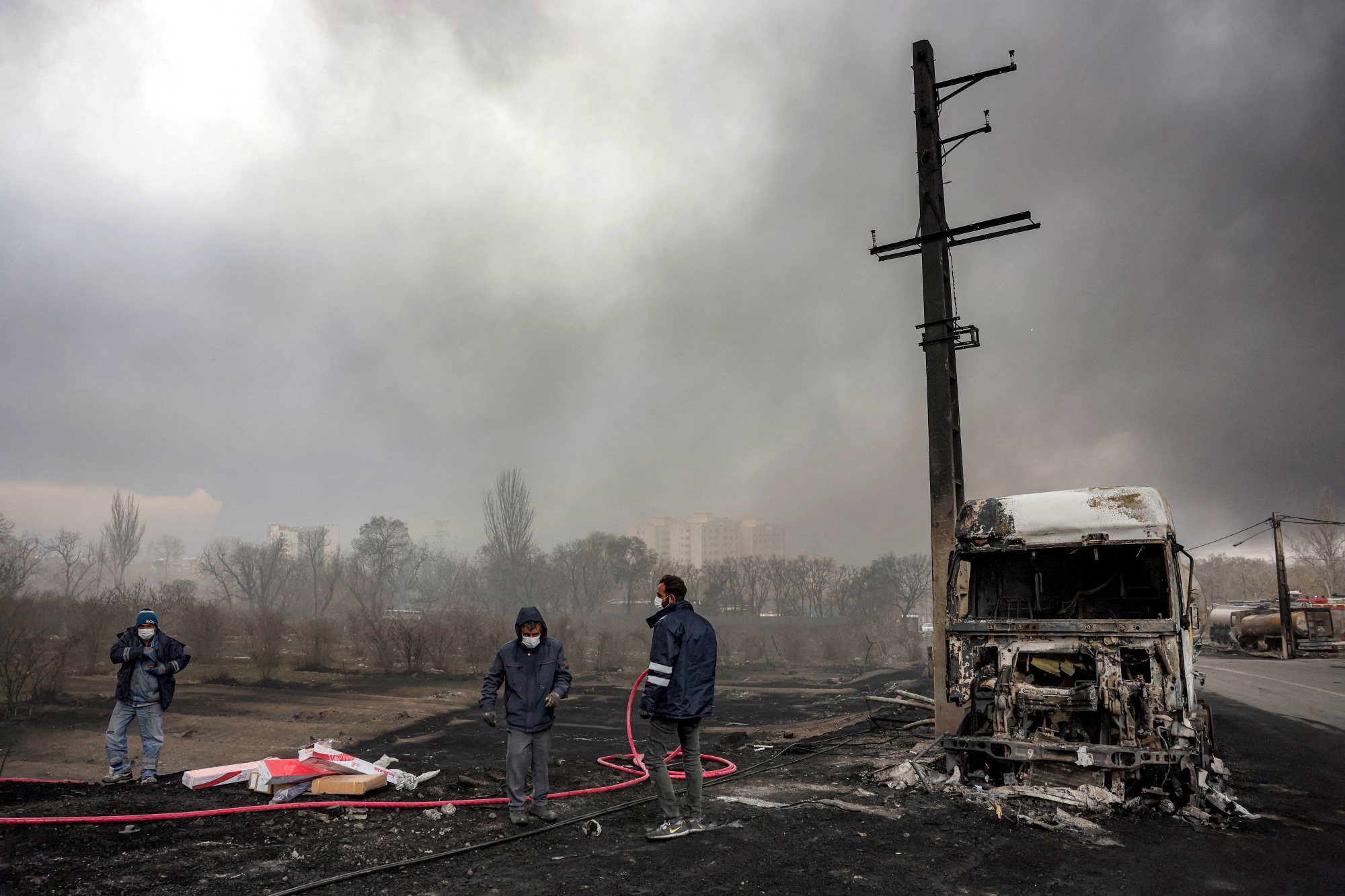 Civil defence members near a destroyed fuel tanker following an overnight airstrike on the Shahran oil refinery in Tehran, on March 8.