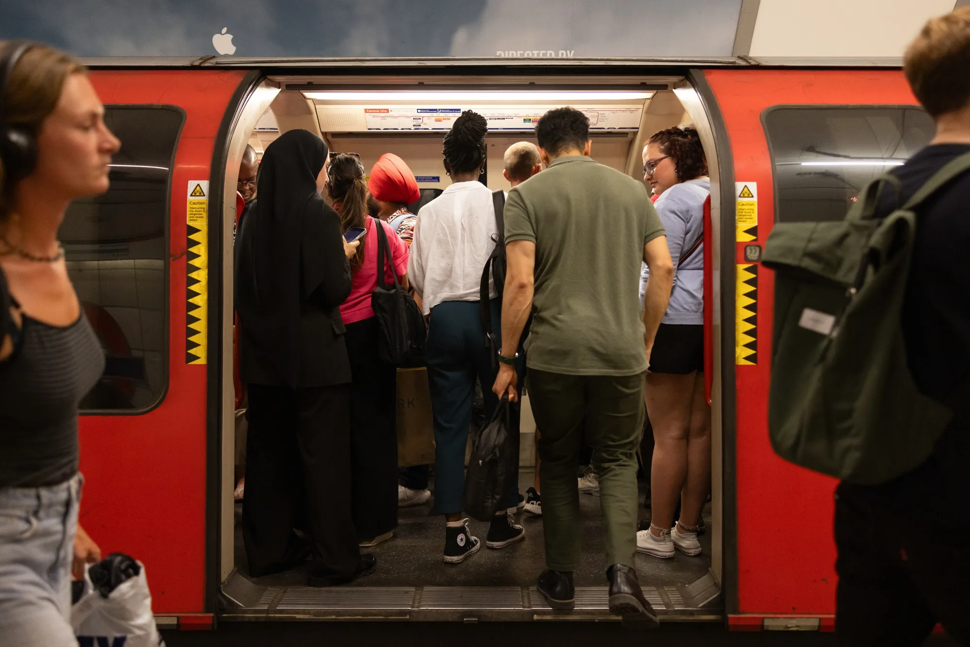Commuters board a train at Bank underground station during a heat wave in London, UK.