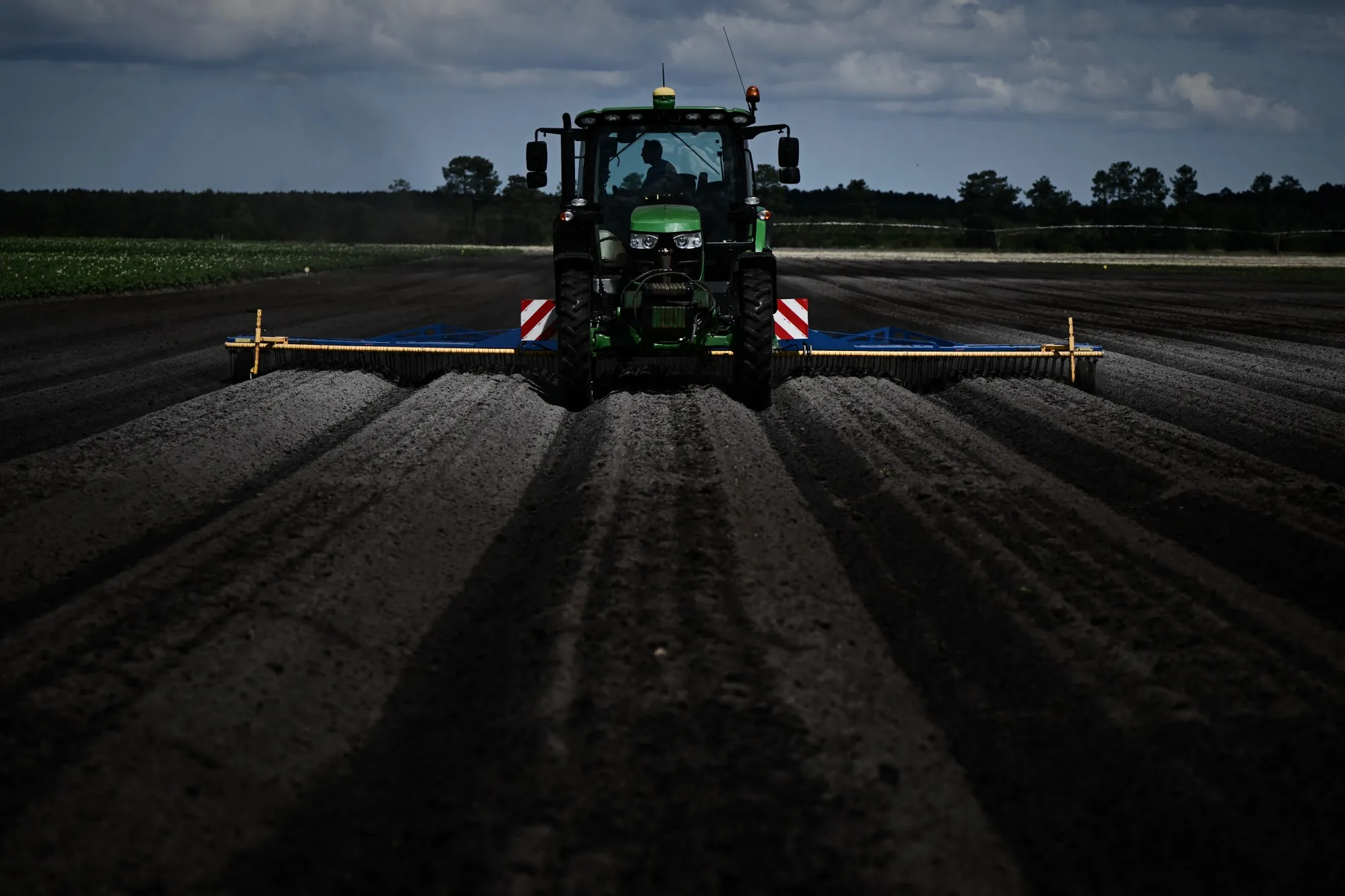 A farmer uses a tractor to spray fertilizer over&nbsp;potatoes at a farm in Saint-Jean-d'Illac, France.