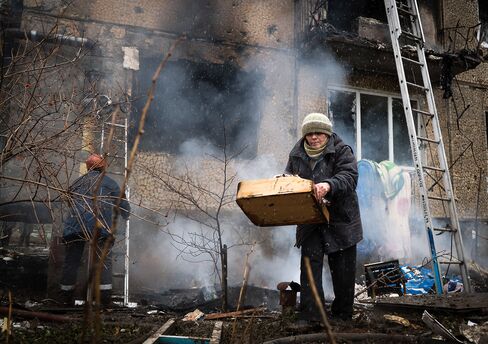 A resident tries to salvage her belongings from a heavily damaged building after shells were exchanged between pro-Russian rebels and Ukrainian forces in Donetsk on Feb. 9, 2015.