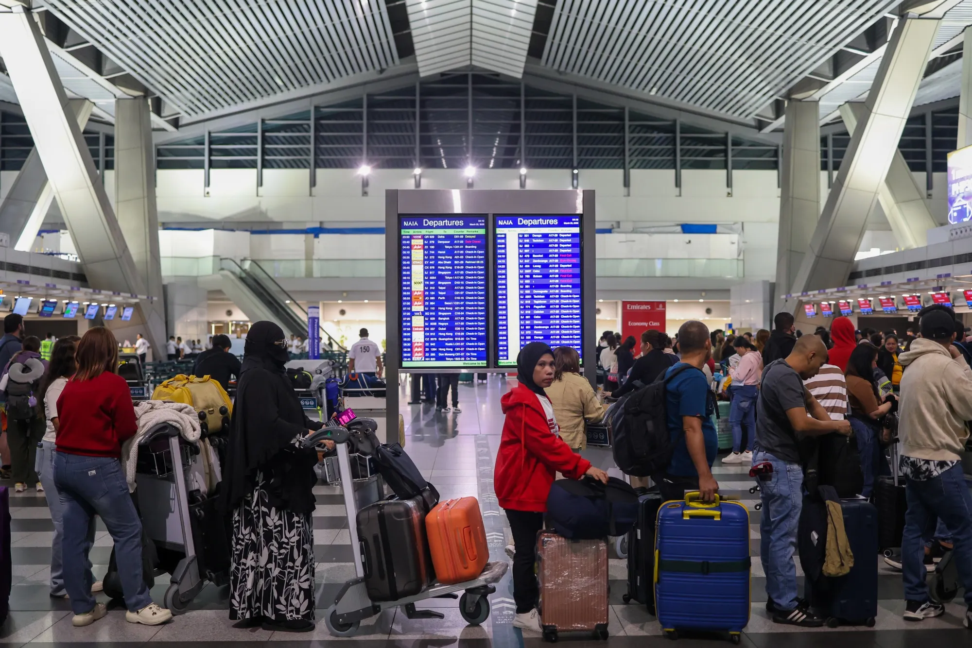International travelers queue up for check in at the Ninoy Aquino International Airport, in Manila.