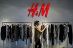 An employee arranges a clothes rail dislaying garments for sale inside an H&M store in Budapest. The company reported fourth-quarter earnings that missed analysts’ estimates.