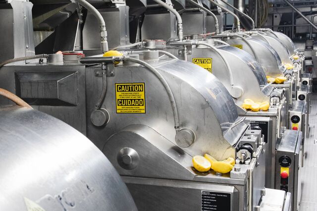 A row of steel extractor machines used for juicing lemons.