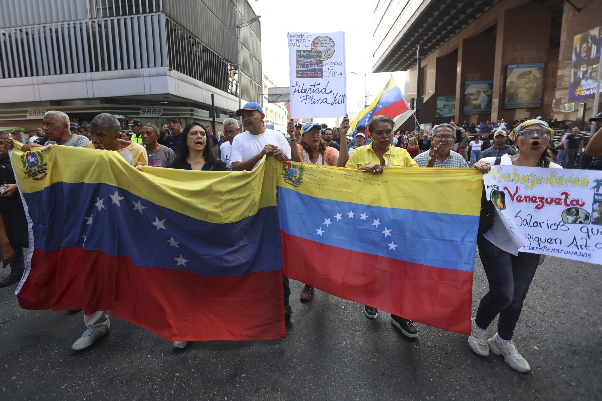 Retired education workers protest holding national flags to demand the immediate approval of the Civil and Labor Amnesty Law in Caracas on Feb. 10, 2026.