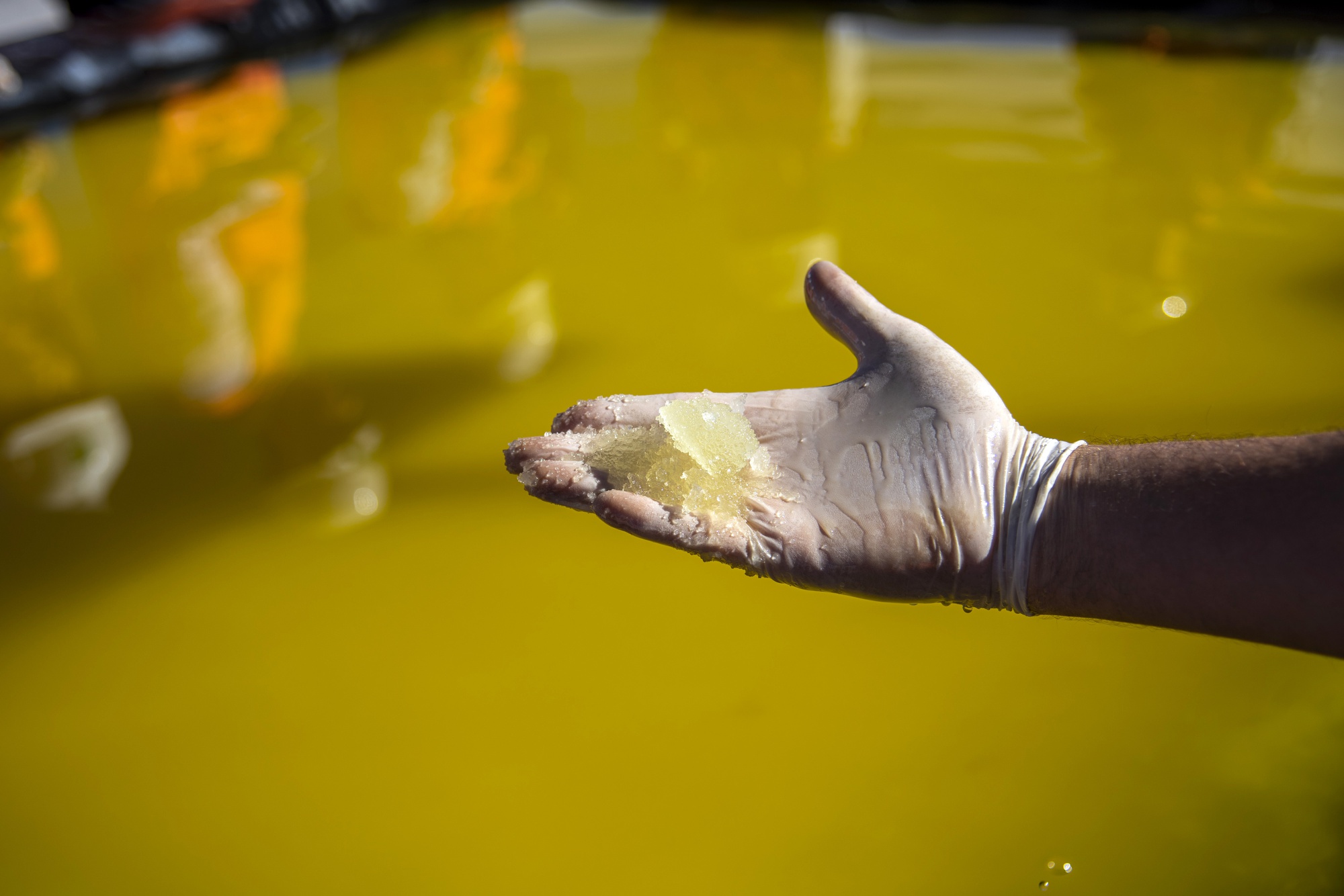 A visitors holds lithium concentrate at a lithium mine in Chile.