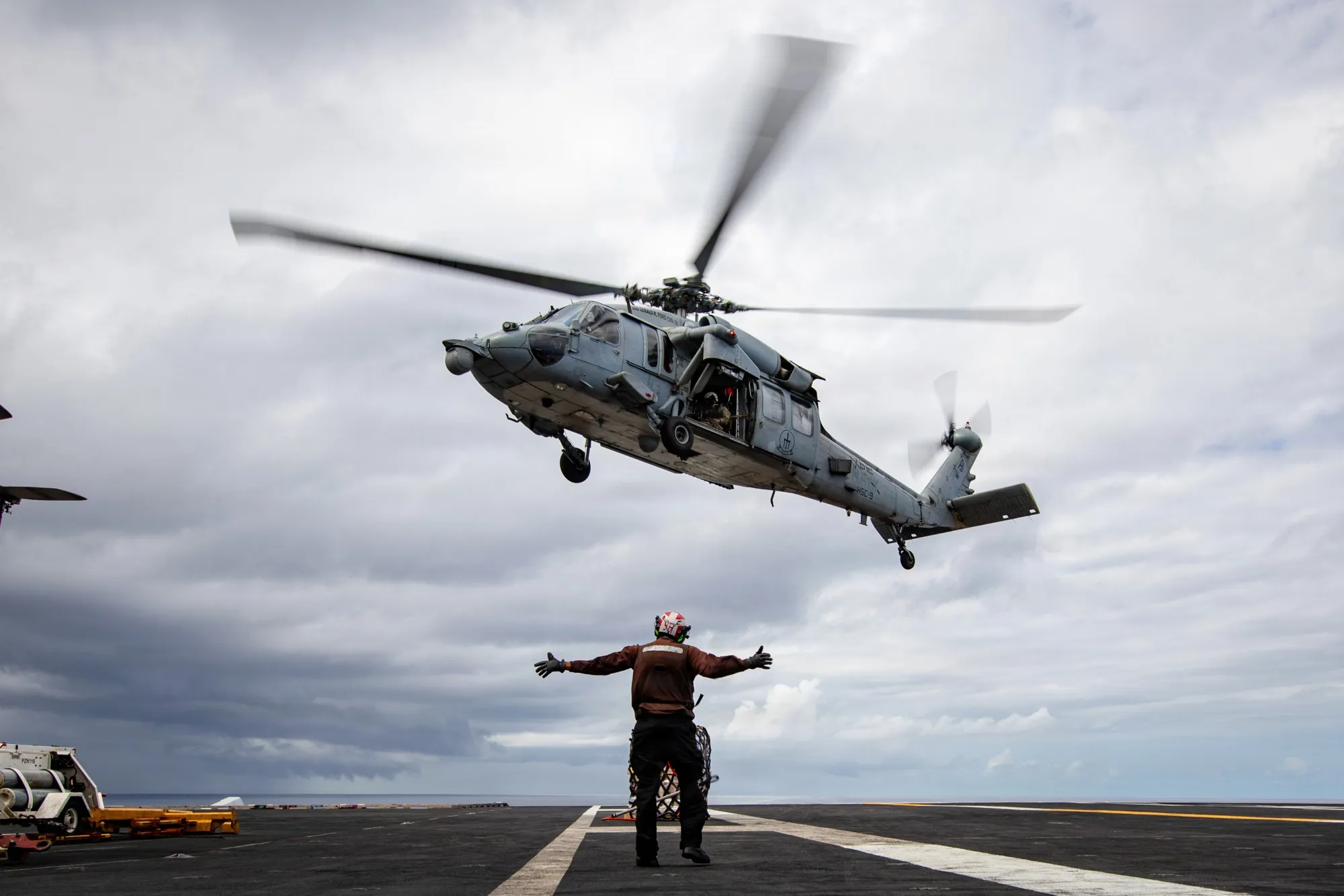 A US Sailor signals a Sea Hawk helicopter as it delivers cargo to the flight deck of the USS Gerald R. Ford on Feb. 7.