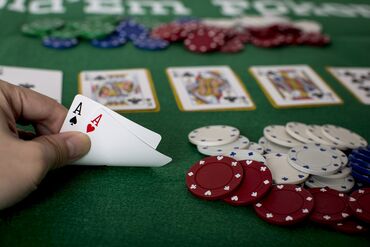 Closeup of hands with two aces, Texas Hold'em Poker gambling concept