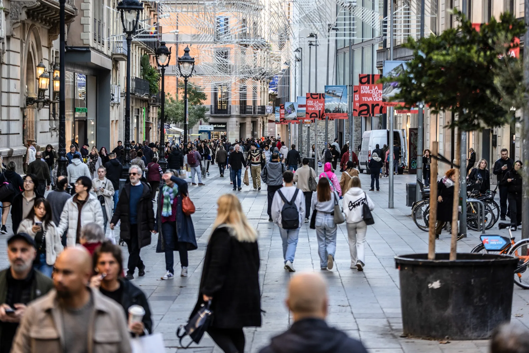 Pedestrians in a shopping street during winter sales in Barcelona.