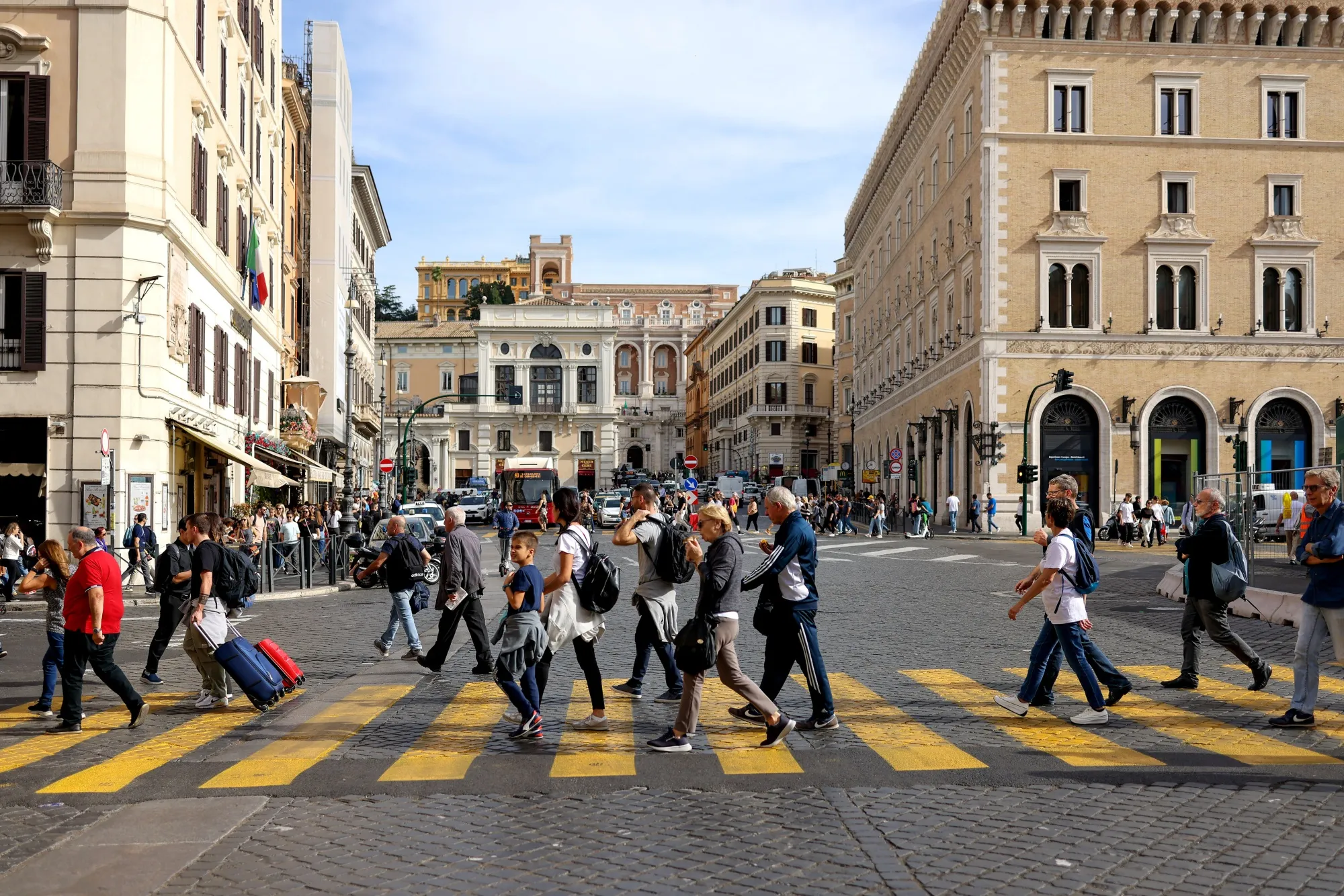 Pedestrians cross Piazza Venezia in downtown Rome, Italy.