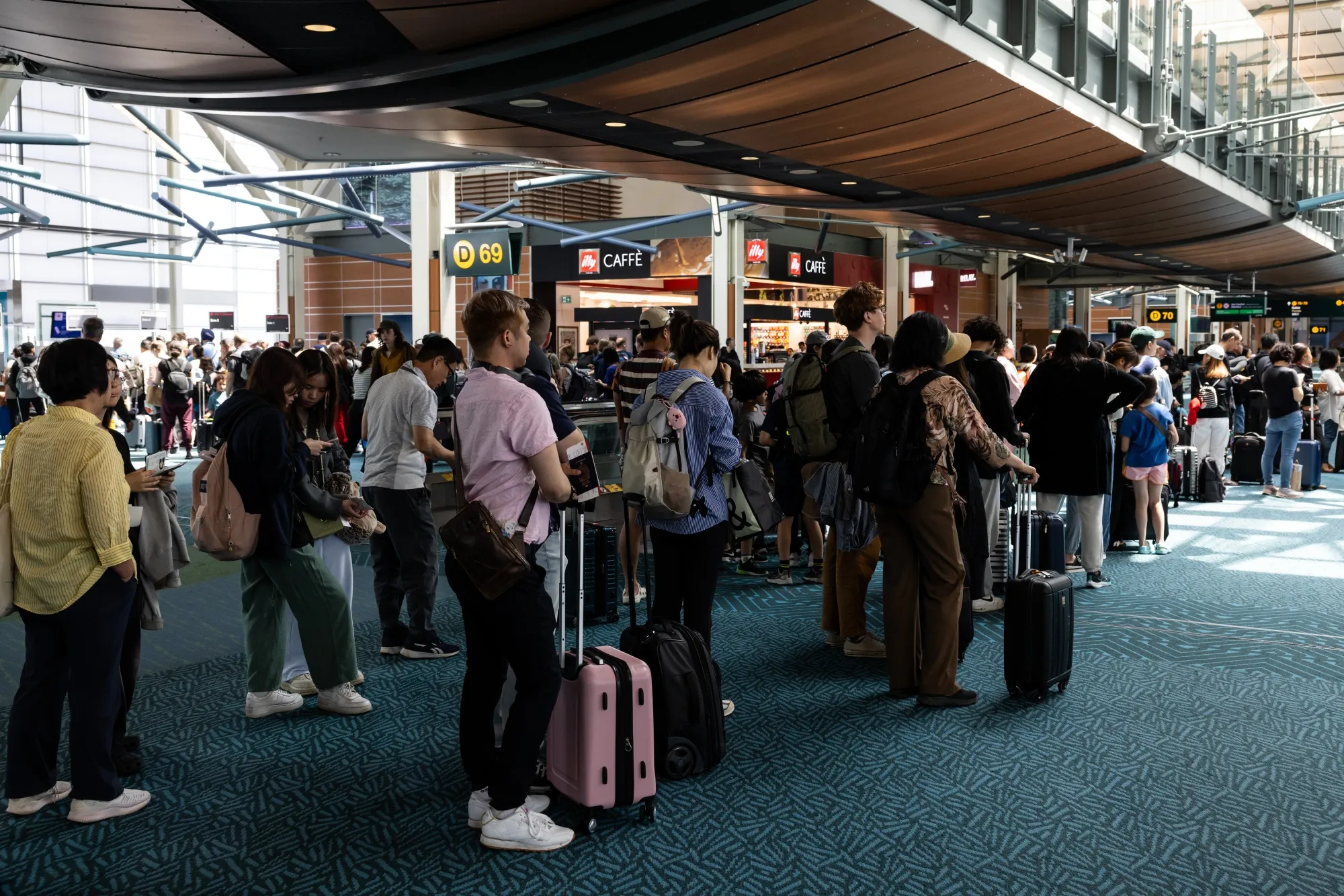Travelers wait in line to board a flight at Vancouver International Airport. The province of British Columbia led job losses in July as the economy shed employment for the second straight month.&nbsp;