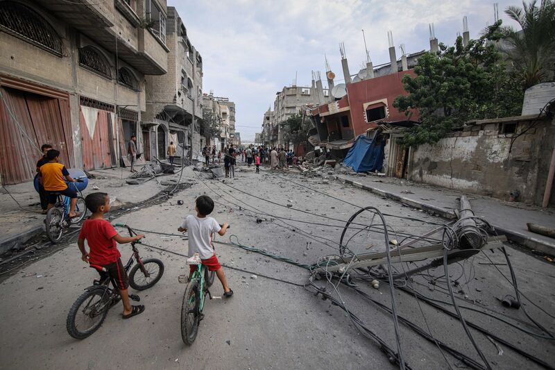 Palestinian children near a destroyed building following Israeli airstrikes overnight in southern Gaza, Oct. 9, 2023. 