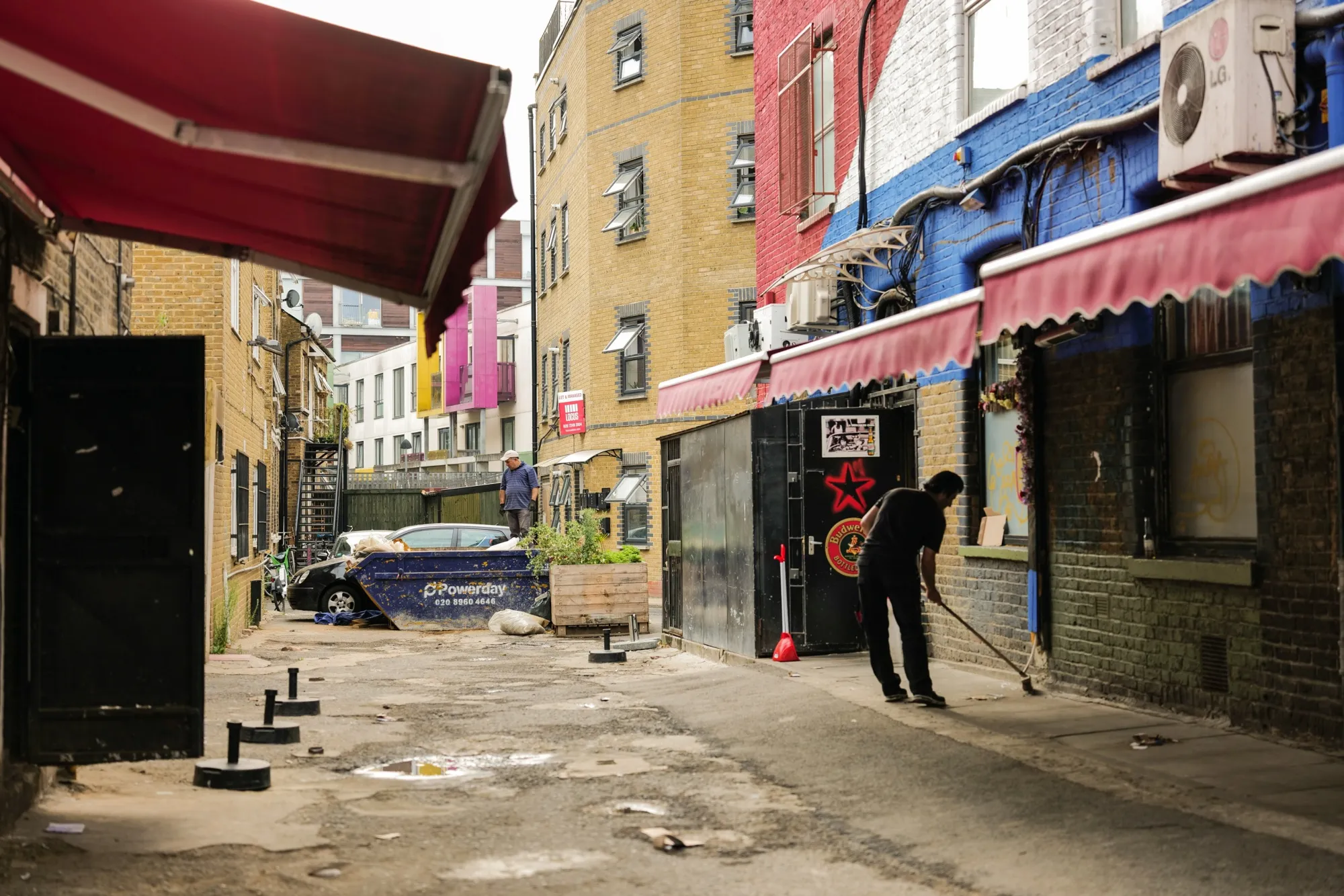 A worker cleans a street in Dalston, London, UK.
