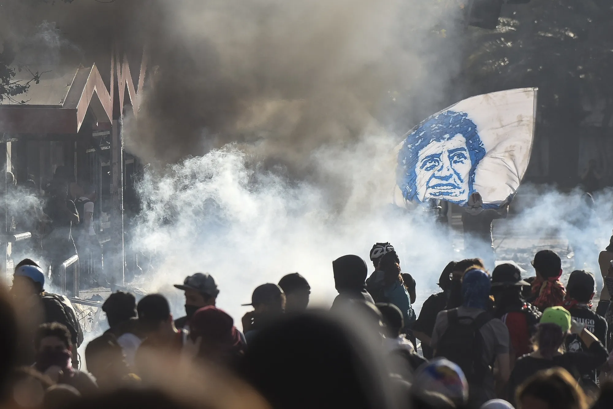 Demonstrators hold a Victor Jaras flag during a protest on Oct. 22.