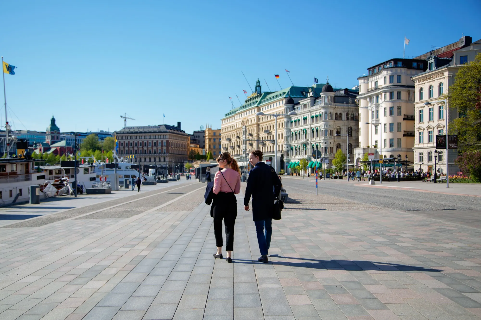 Pedestrians walk near the habour in Stockholm, on May 22.