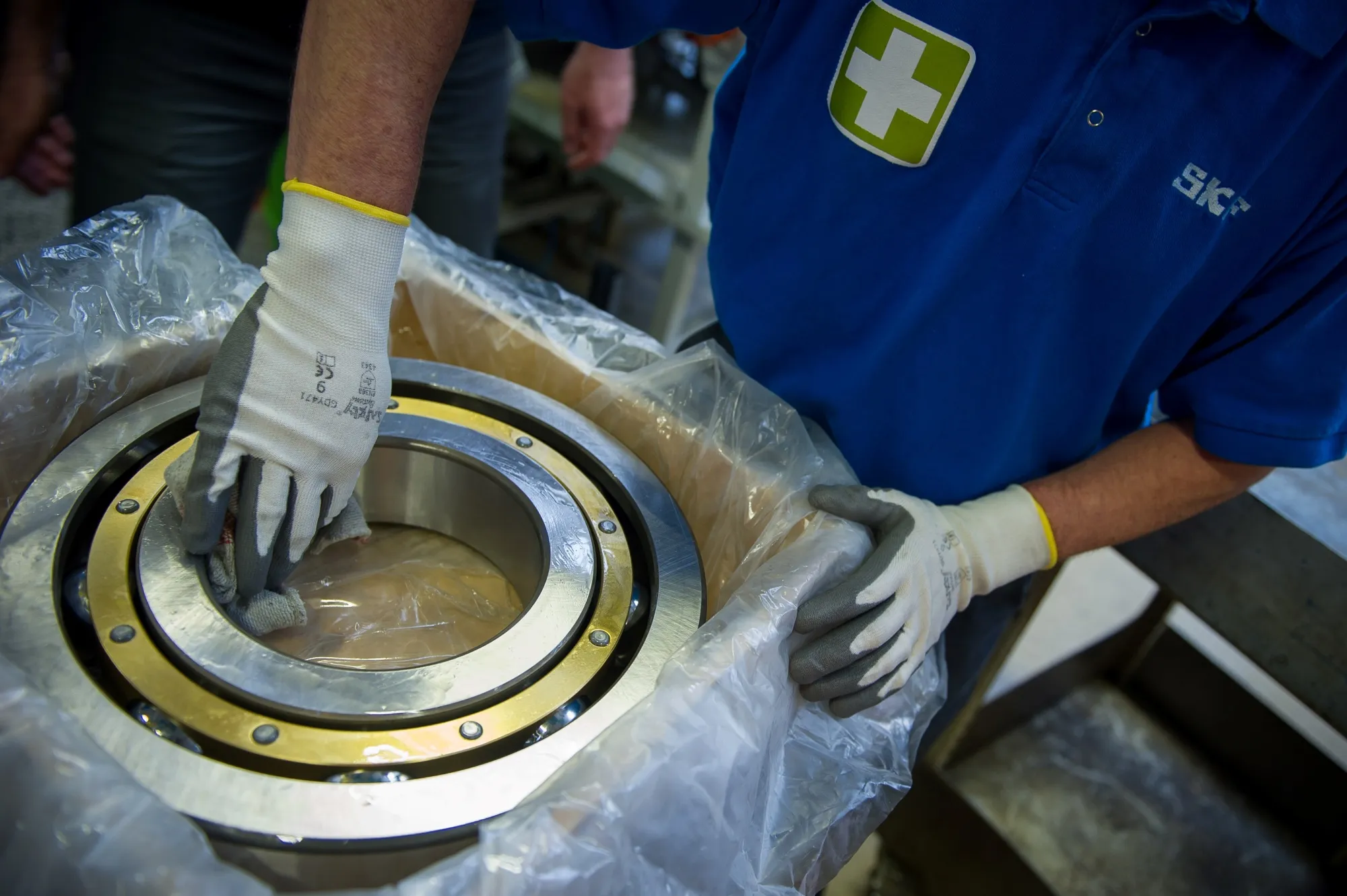 An employee works on a ball bearing for a wind turbine generator inside a&nbsp; SKF plant.