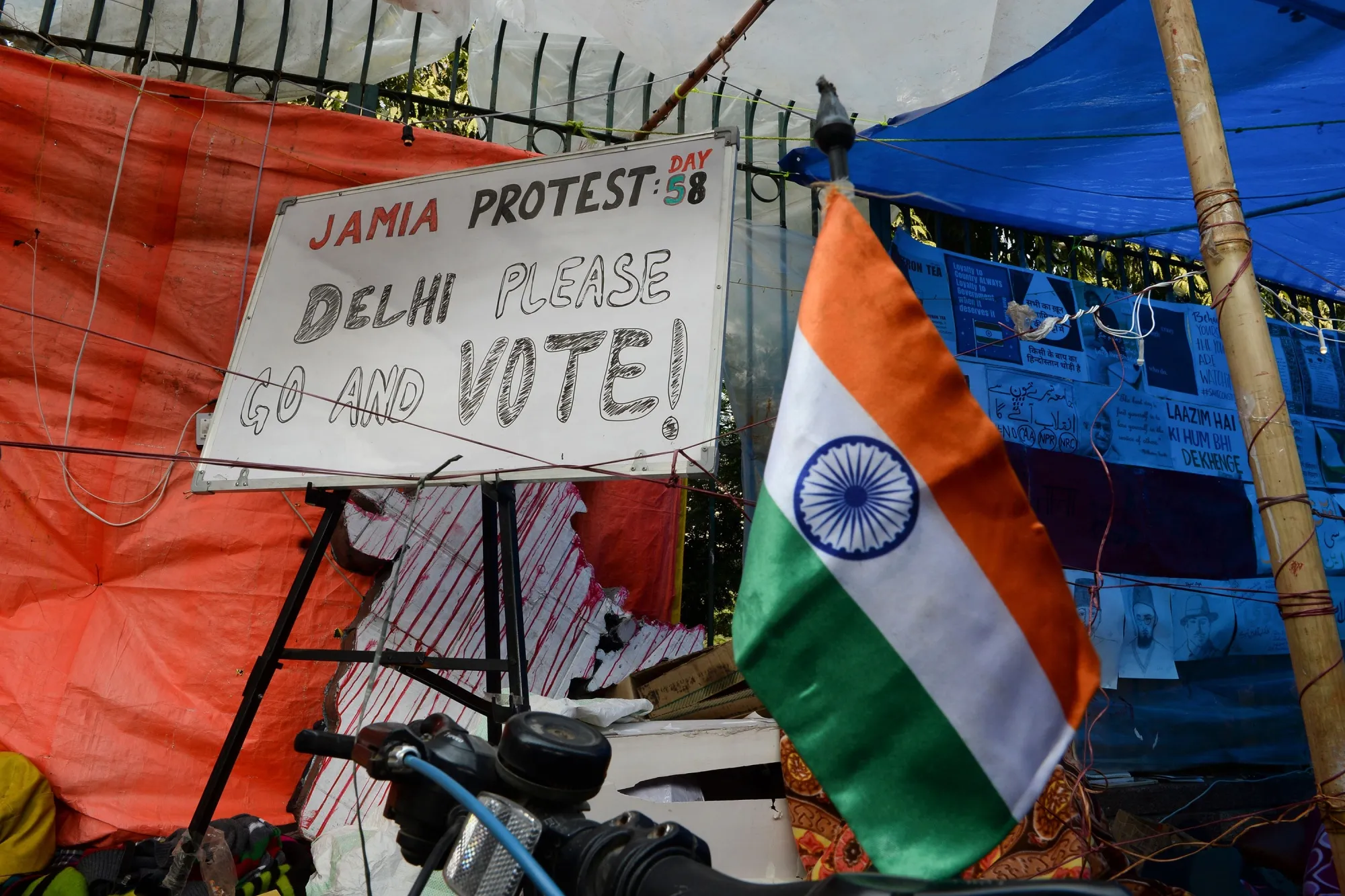 A placard reading 'Delhi Please go and Vote' sits outside Jamia Millia Islamia University, in New Delhi.