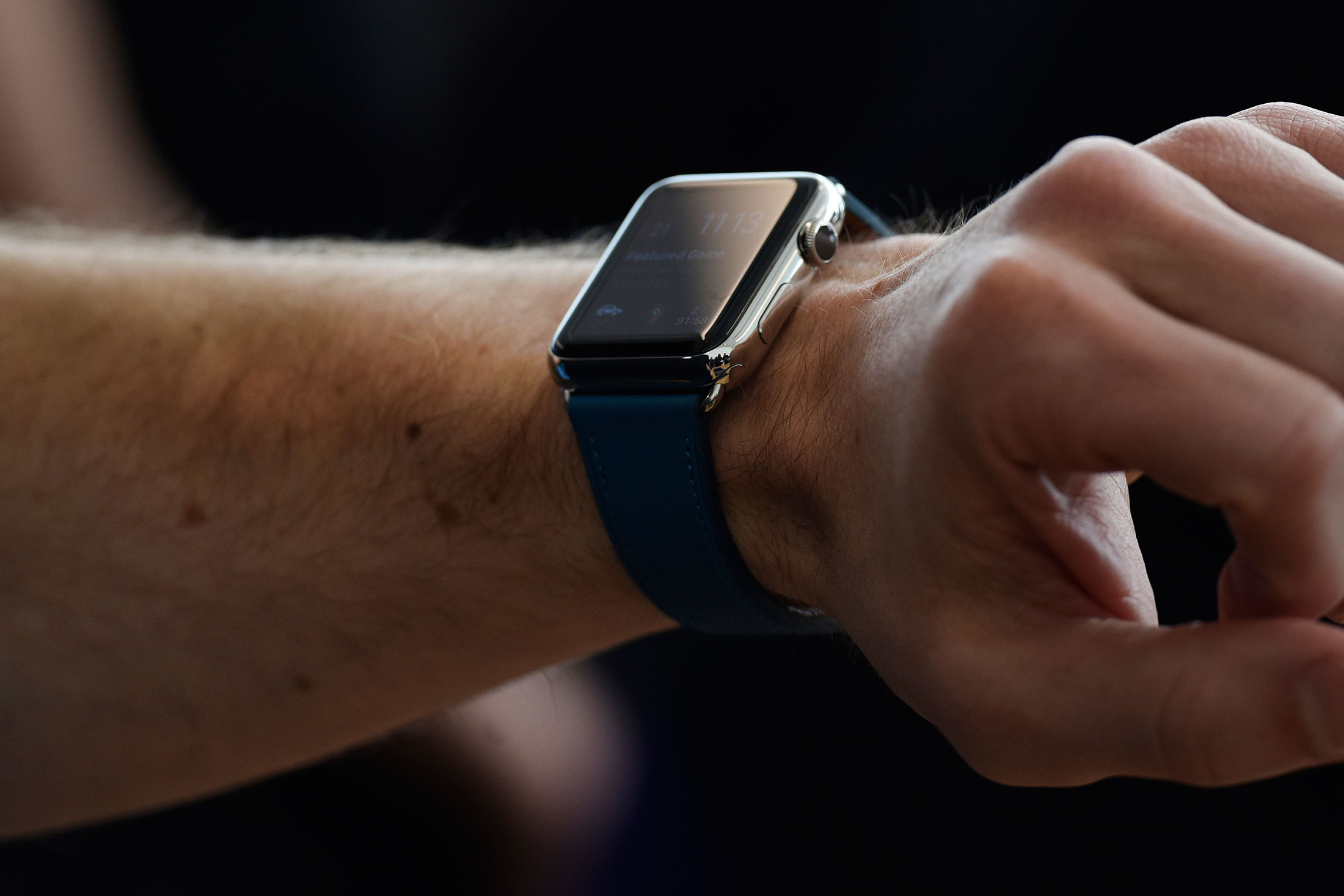 An attendee tries on the Apple Watch after an Apple Inc. event in Cupertino, California, U.S., on Monday, March 21, 2016. Apple Inc. unveiled a new, smaller iPhone that will start at $399, seeking to jump-start sales of its flagship product by enticing more users to upgrade, especially in high-growth markets such as China and India.
