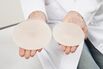 Germany, Munich, Doctor holding breast implant, close up