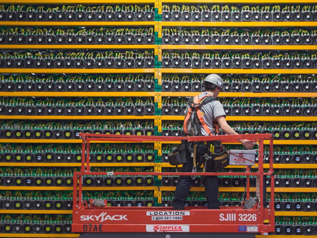 A technician inspects the backside of bitcoin mining in Saint Hyacinthe, Quebec.