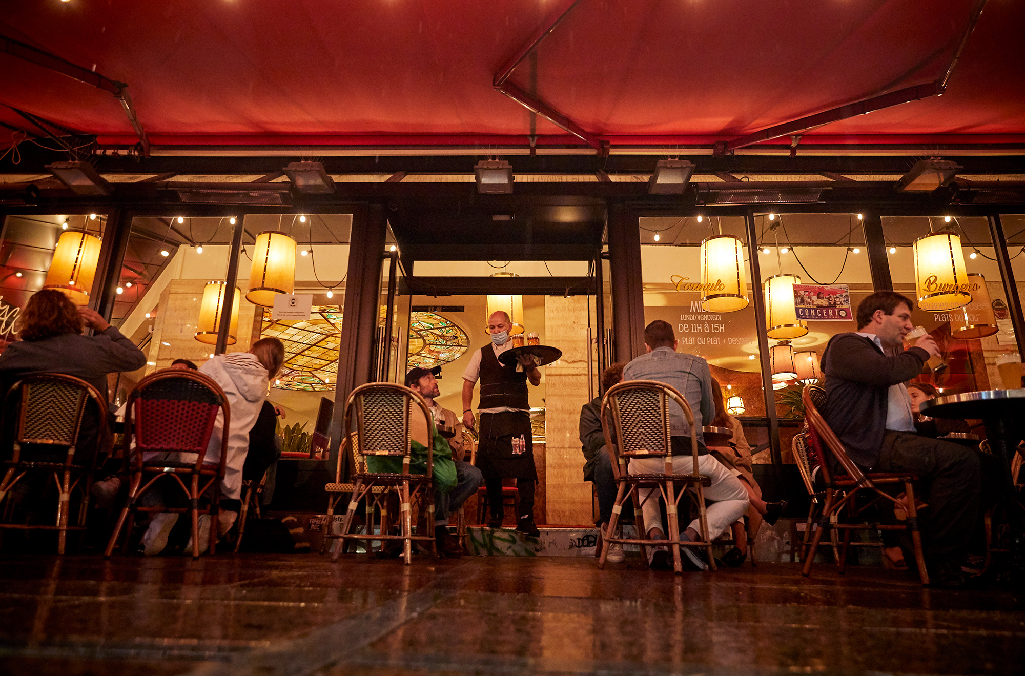 A waiter serves customers at a bar in Paris ahead of tightening restrictions, on Sept. 23. 