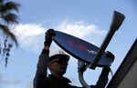 A Dish Network field service specialist installs a satellite television system in Downey, California, U.S.