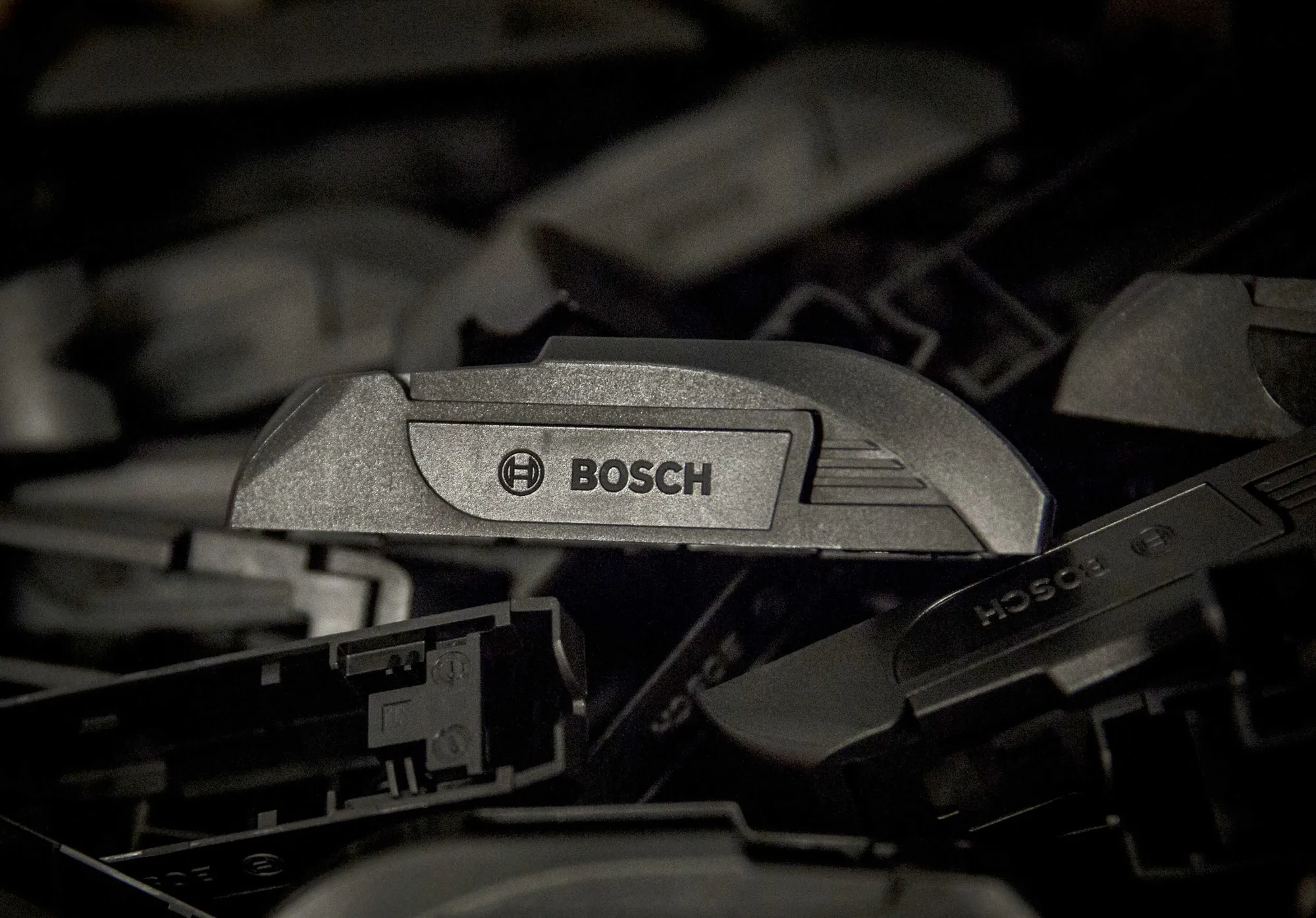 Automobile windshield wiper blade arm fittings sit on the assembly line at a Robert Bosch plant.