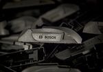 Automobile windshield wiper blade arm fittings sit on the assembly line at a Robert Bosch plant.
