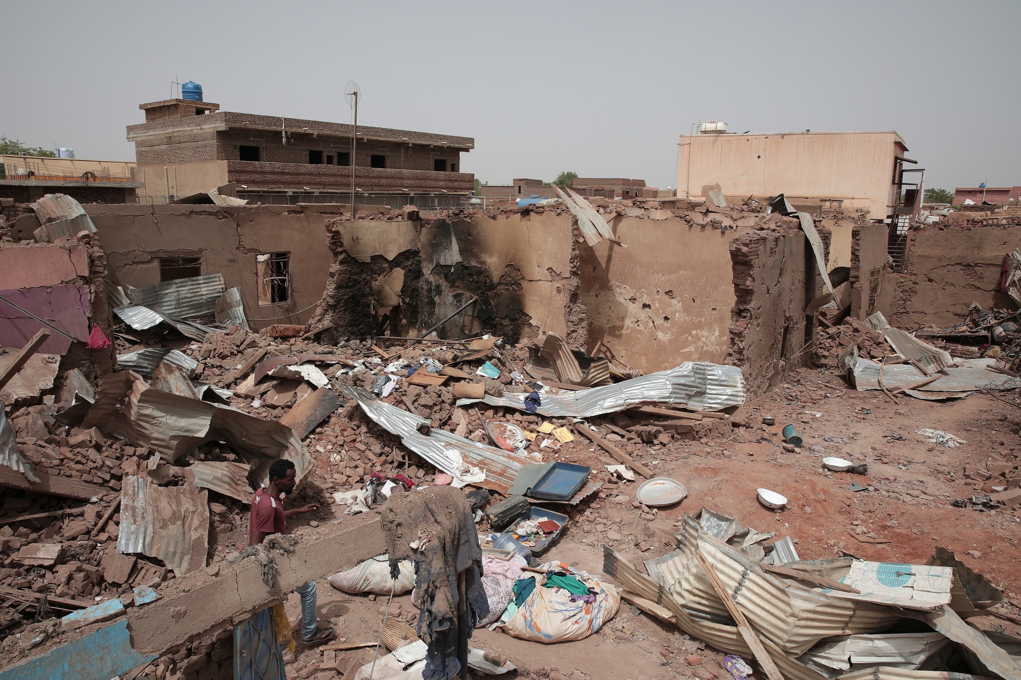 A man walks by a house damaged during&nbsp;recent fighting in Khartoum, Sudan, on April 25.