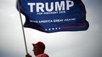 An attendee waves a campaign flag outside of an event for Donald Trump in Cincinnati, Ohio, on July 6, 2016.
