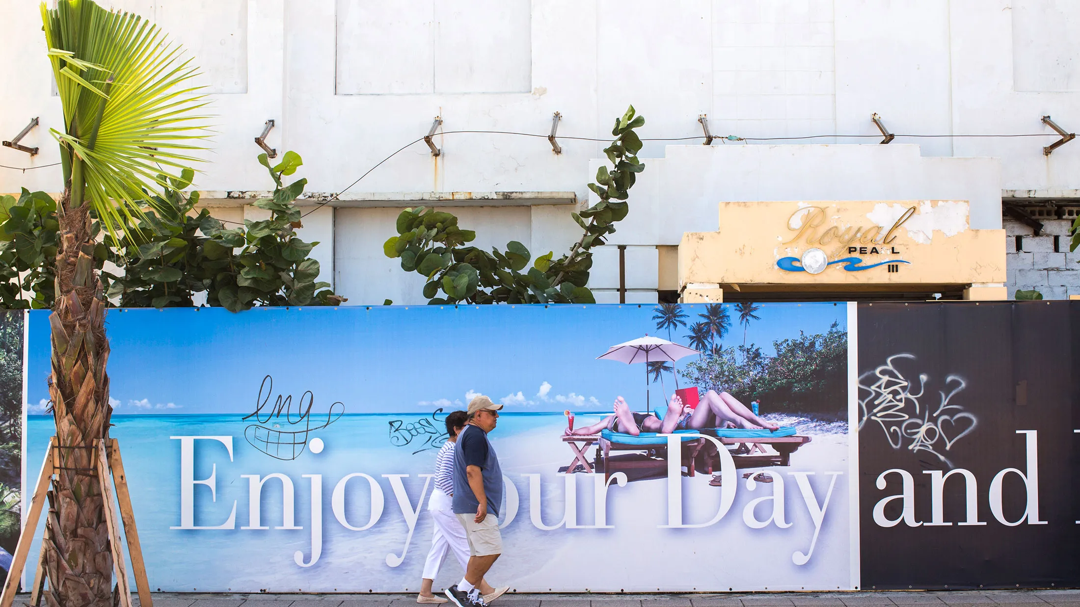 A couple walks past a vacant building in the upscale Condado neighborhood of San Juan, Puerto Rico.
