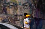 Pedestrians walk past a mural of former South African President Nelson Mandela&nbsp;in Cape Town.