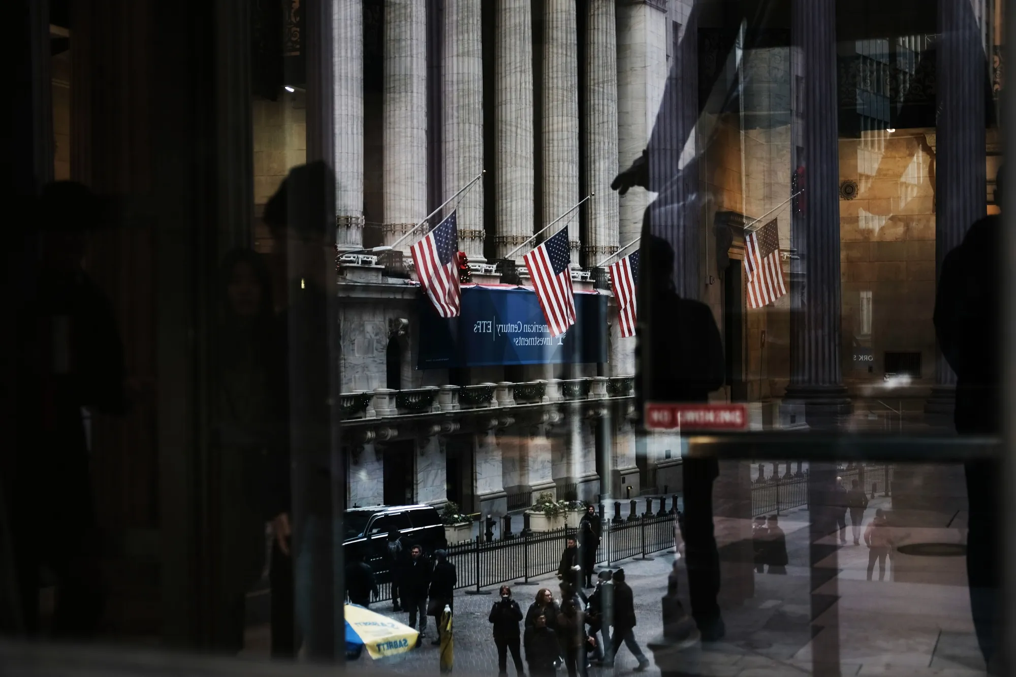People walk by the New York Stock Exchange.