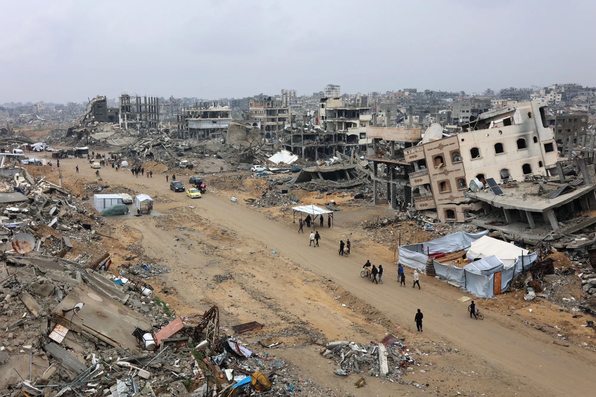 People walk amid collapsed buildings along Saftawi street in Jabalia in the northern Gaza Strip on Feb. 5, 2025