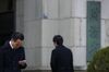 A man uses his mobile device as he exits the Ministry of Finance building in Tokyo, Japan.