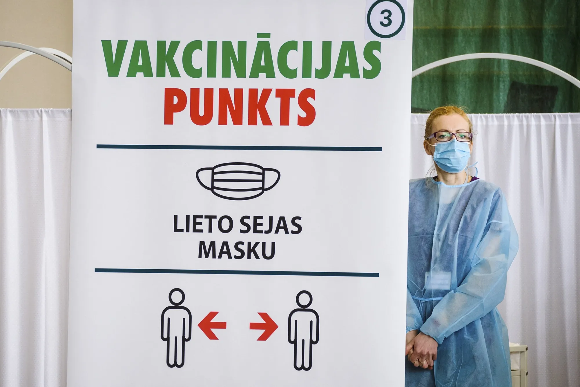 A medical worker waits for patients next to a sign for social distancing measures at a vaccination center&nbsp;in Ventspils, Latvia.
