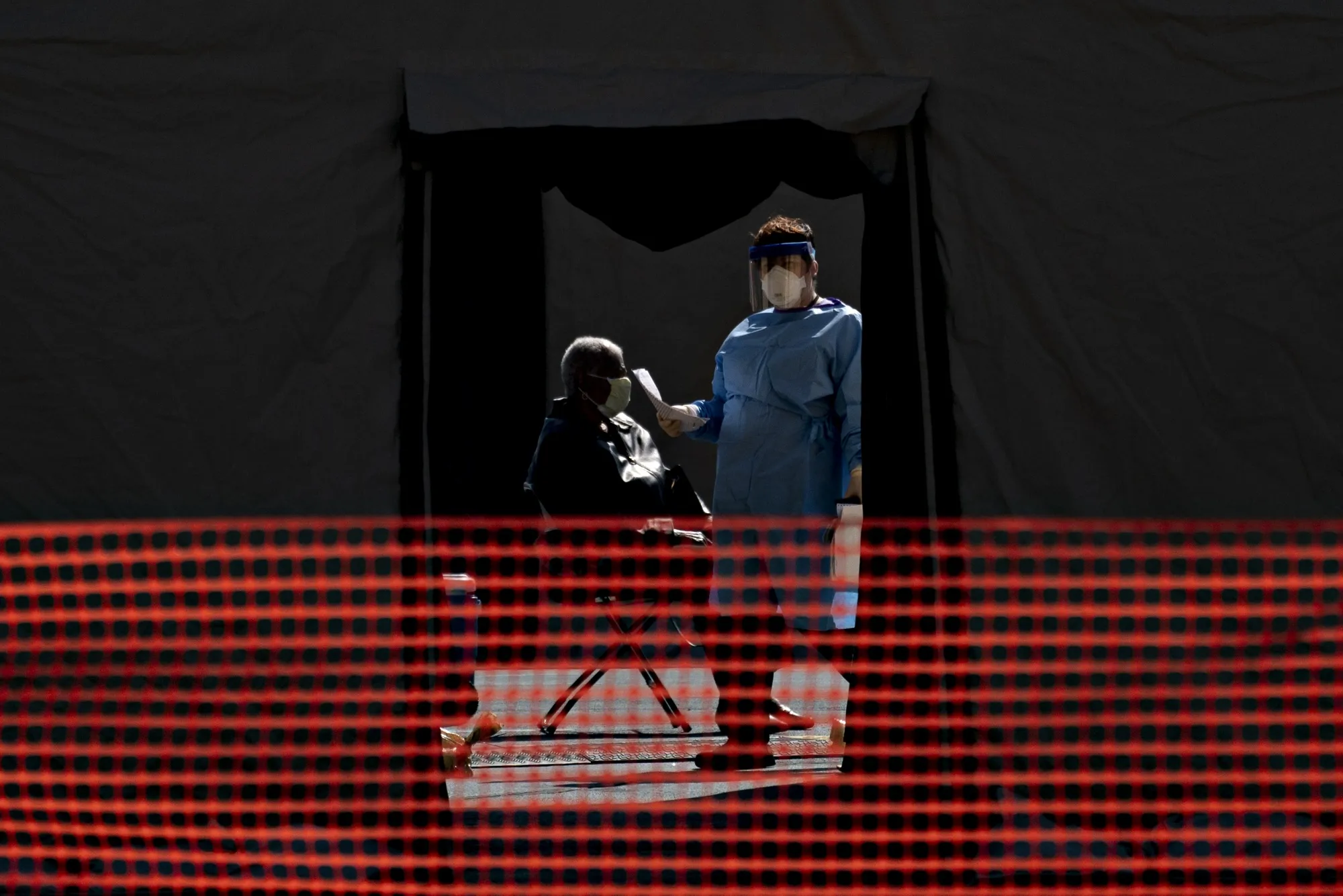 A healthcare worker walks into a tent at a coronavirus testing site run by the Prince Georges County Department of Health outside FedEx Field in Landover, Maryland, U.S., on March 30.