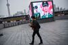 A woman wearing a protective mask walks to the promenade of the Bund along the Huangpu River in Shanghai on January 21, 2020.