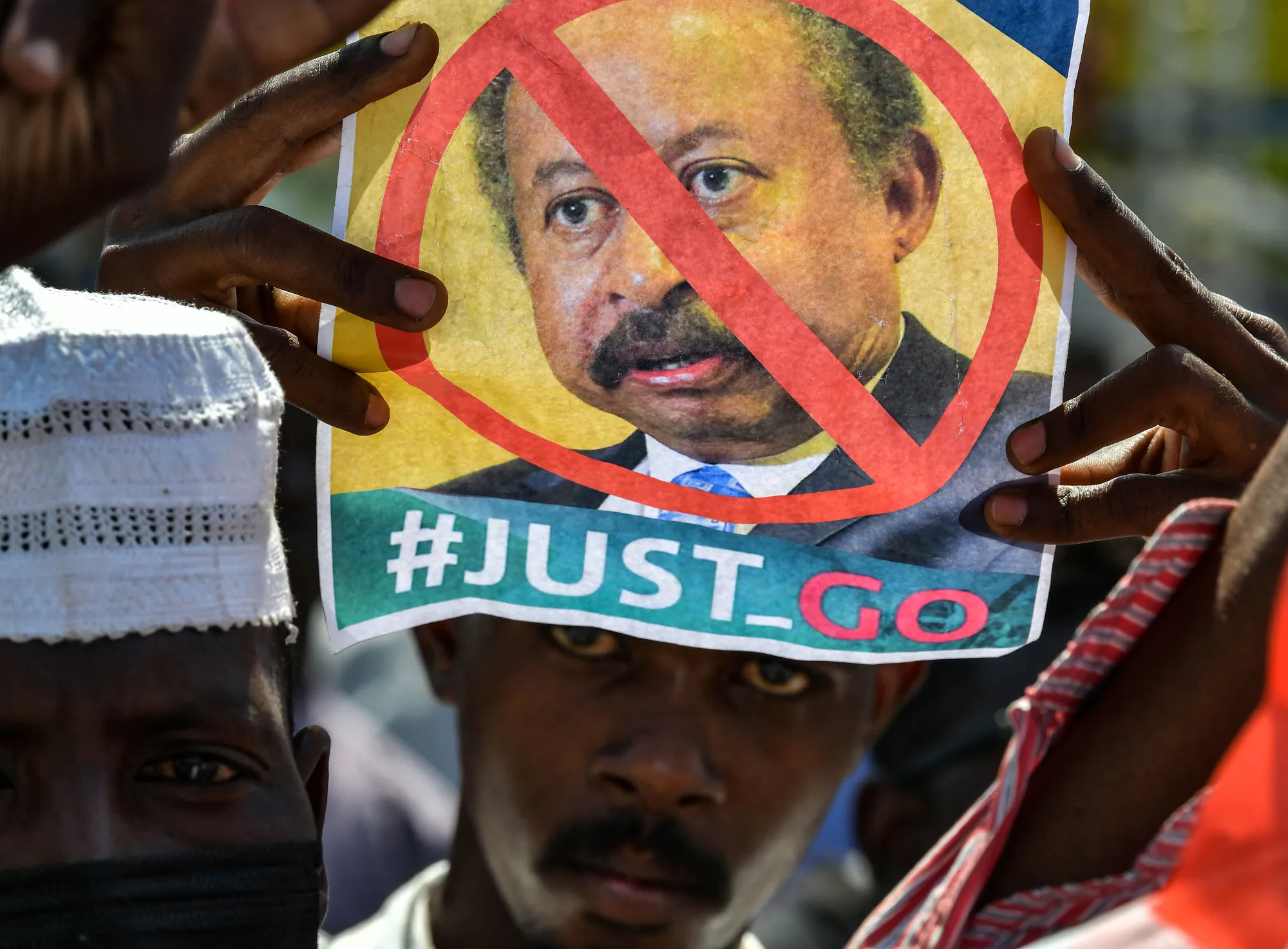 Demonstrators hold an image of Abdalla Hamdok during a protest at the presidential palace in Khartoum, Sudan, on Oct. 21.