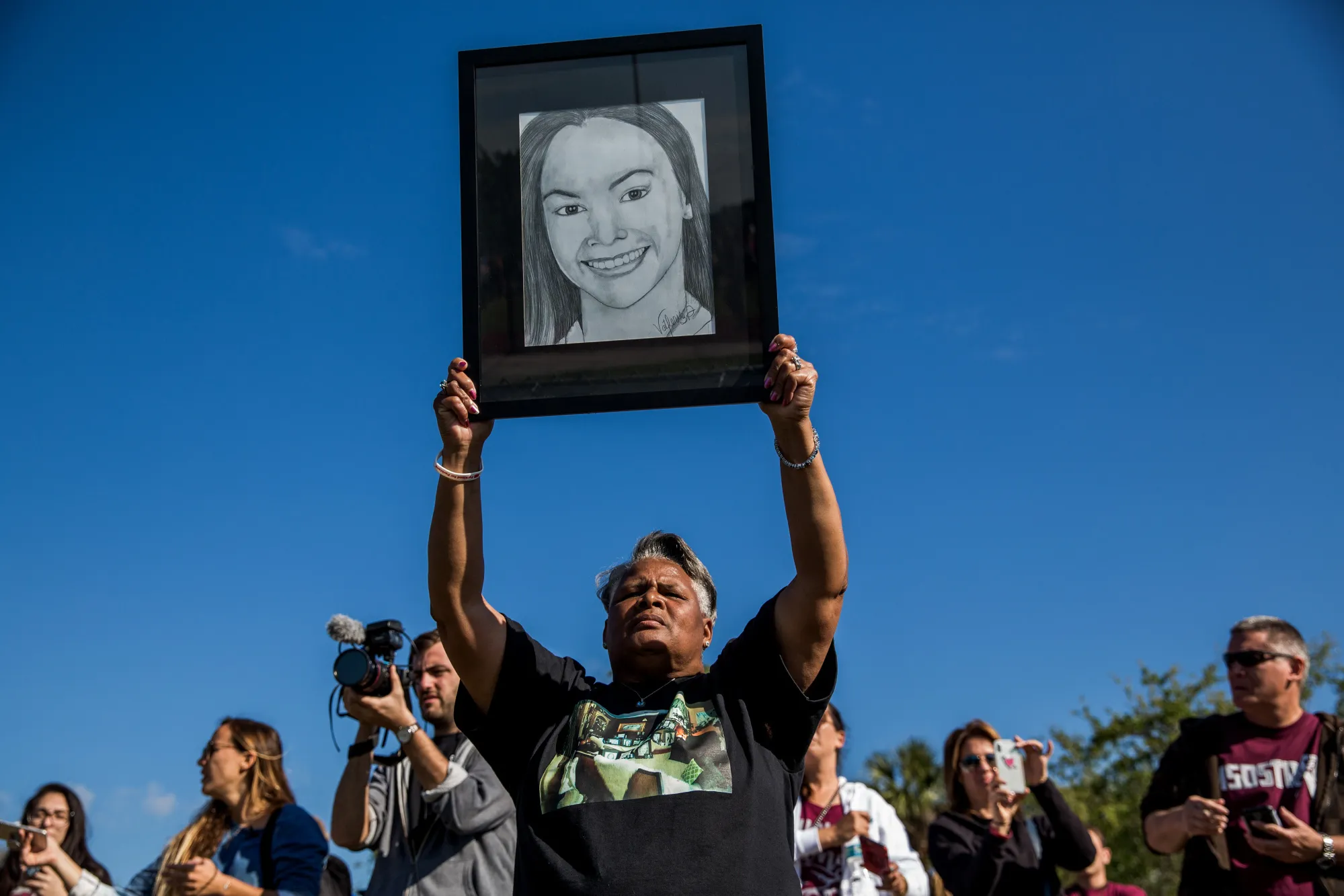 A woman holds up a drawing of Marjory Stoneman Douglas high school shooting victim Meadow Pollack.