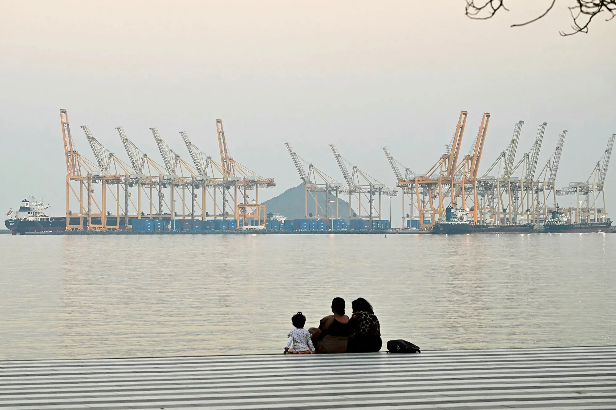 A family looks toward a dockyard off coast city of Fujairah, in the Strait of Hormuz.&nbsp;