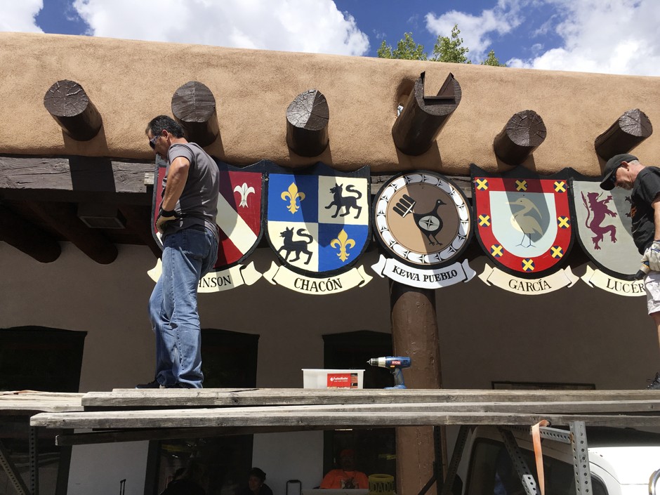 Shields of the last names of Santa Fe's original Spanish settler families hang on the Palace of the Governors while American Indian jewelers sell items below.